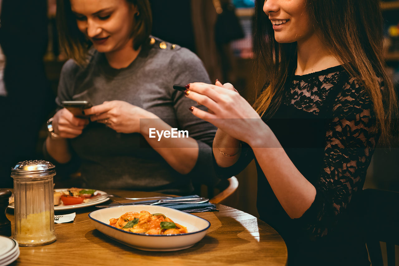 Women photographing food in restaurant