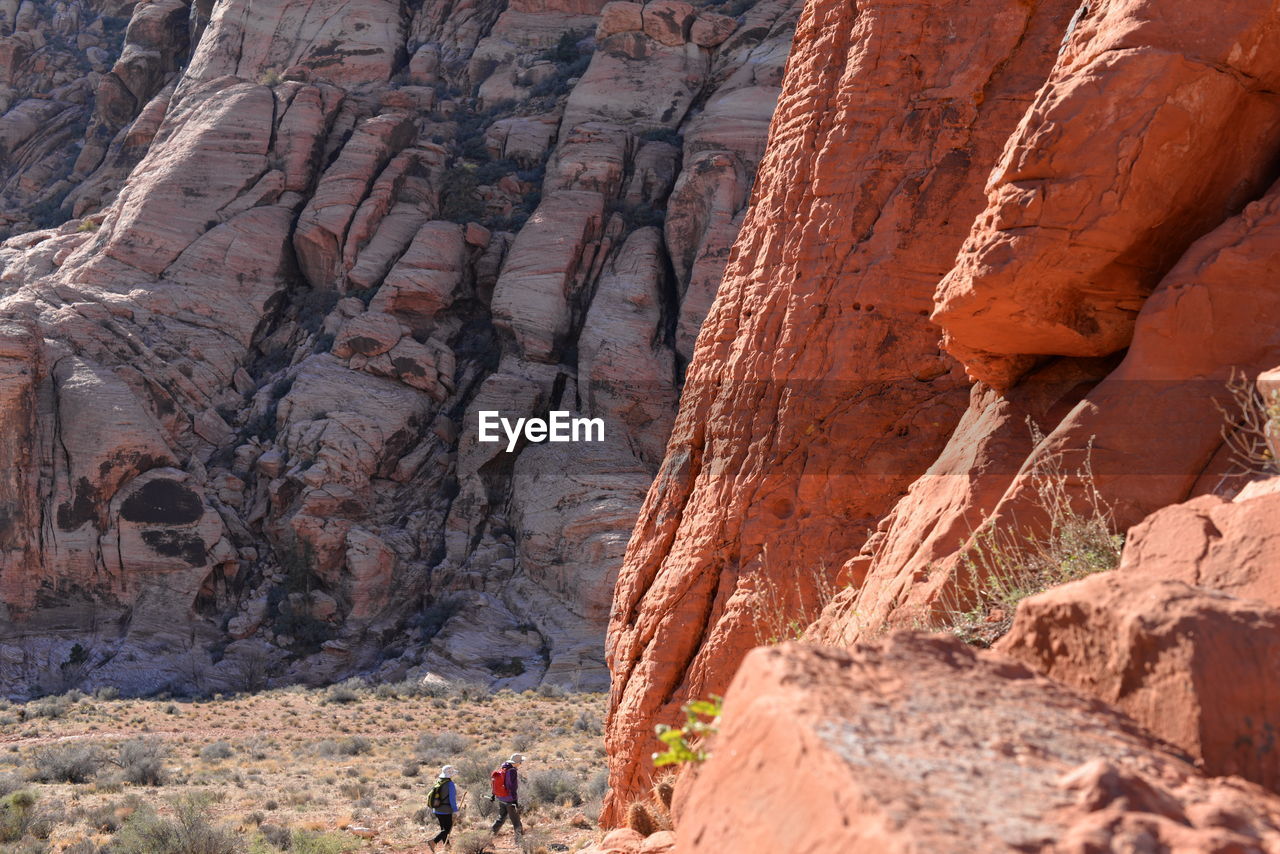 High angle view of friends walking towards rocky mountains