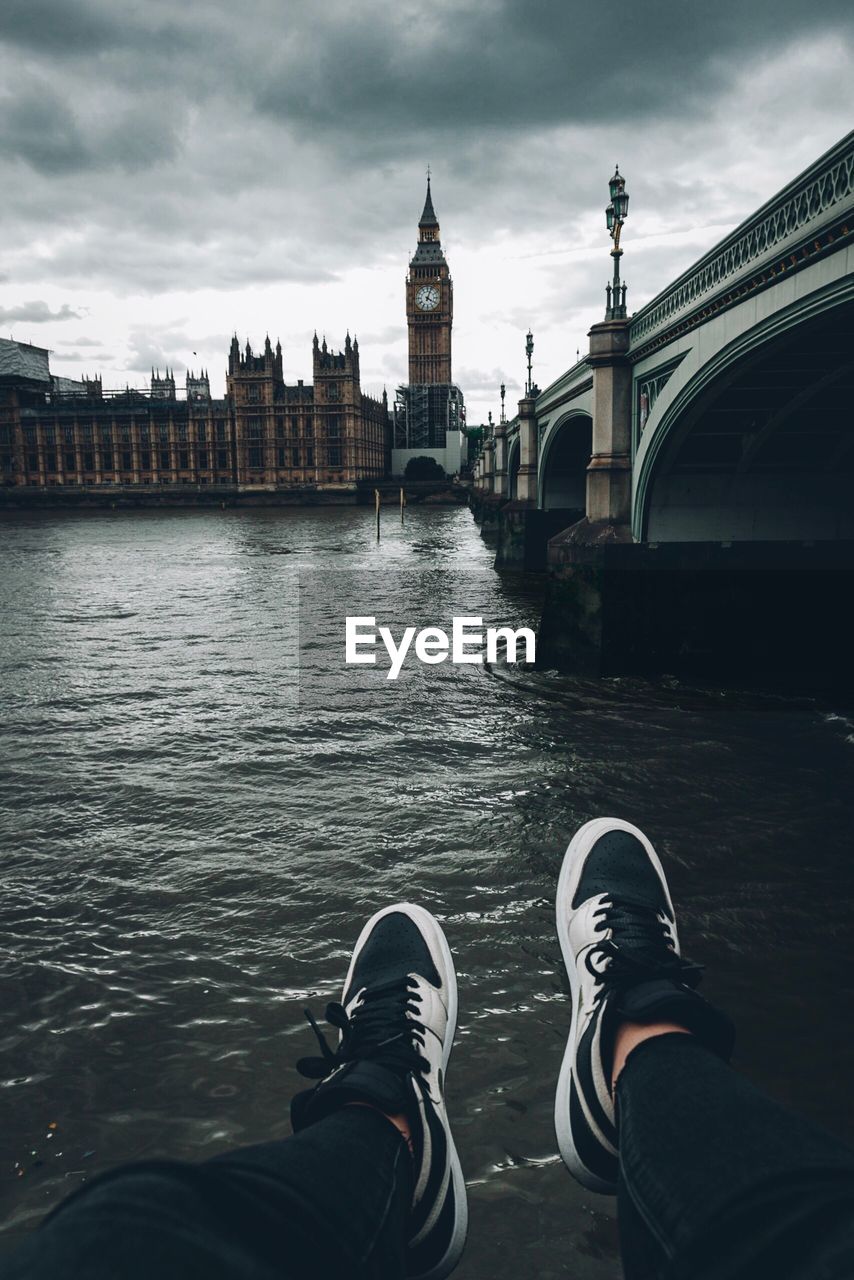 Low section of man by river against big ben