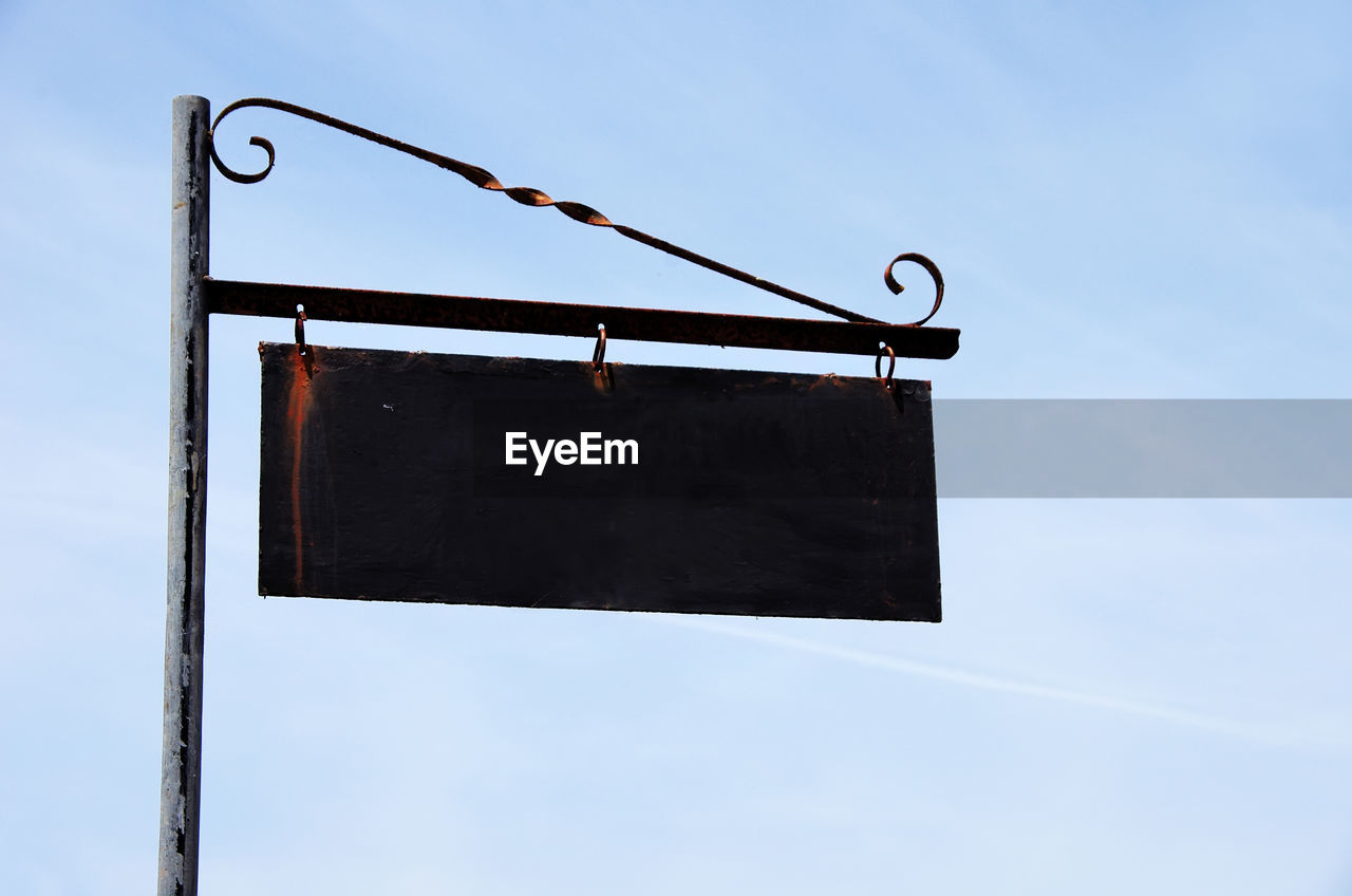 Low angle view of sign board against sky