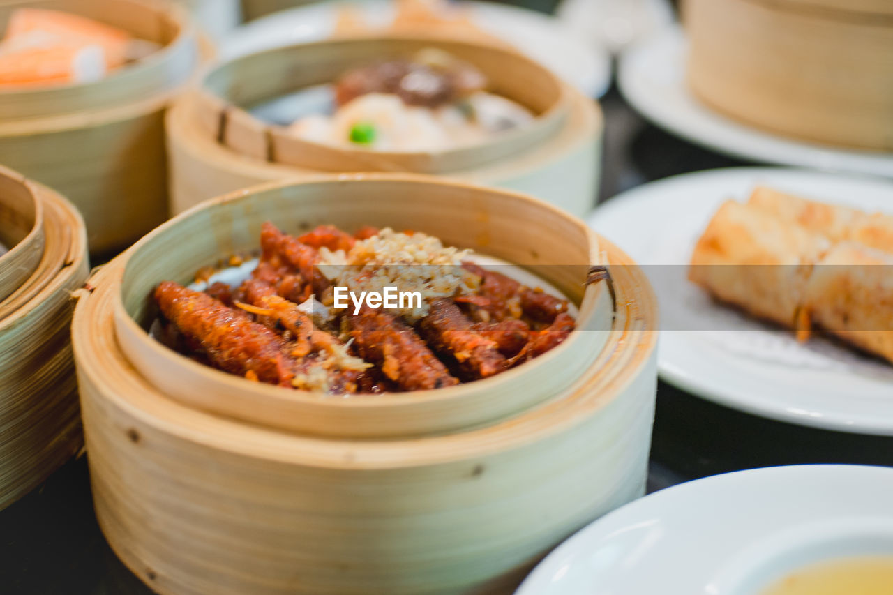 Close-up of dim sums served in steamers on table