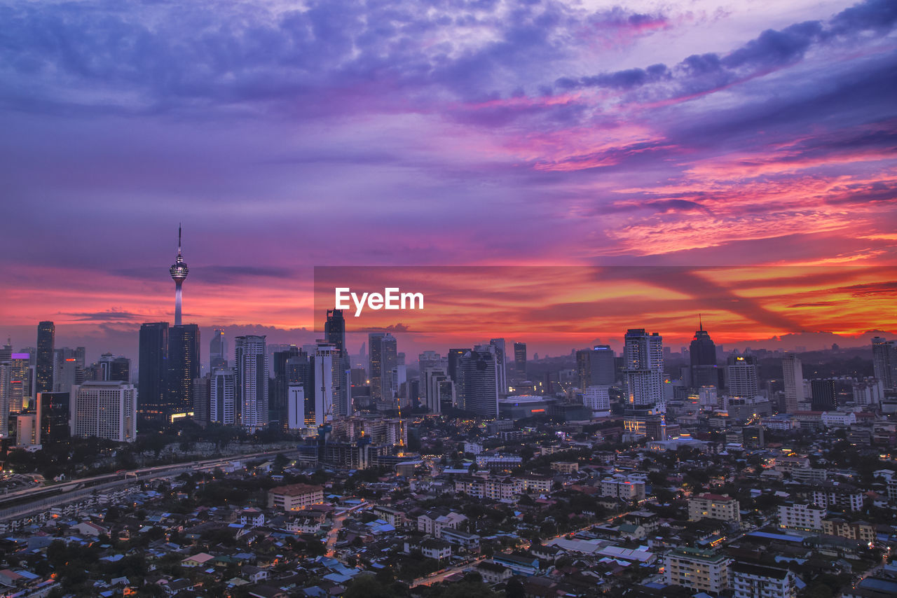 High angle view of buildings against cloudy sky at sunset