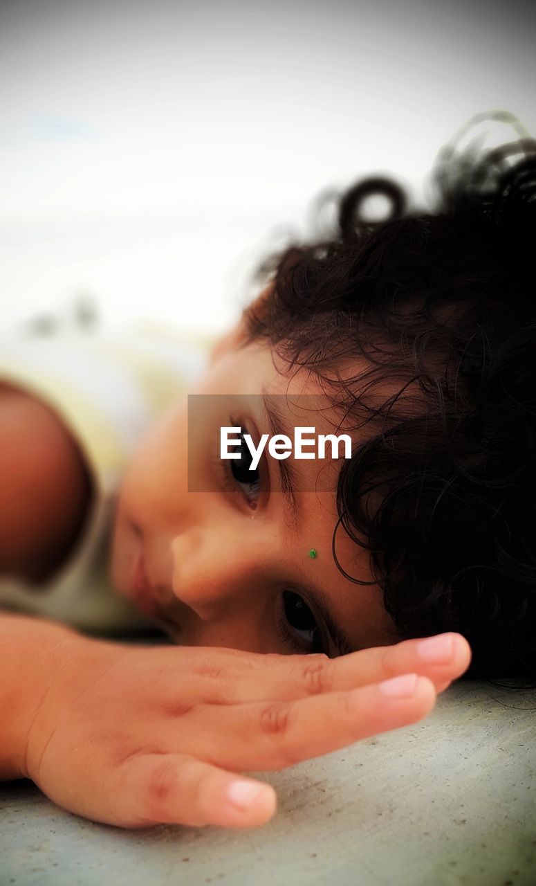 Close-up of cute baby girl lying down