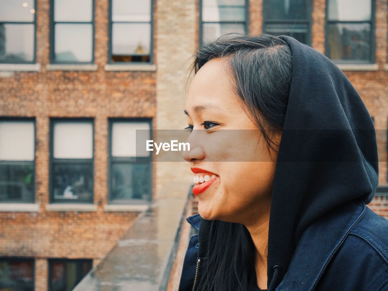 Portrait of happy young woman on balcony