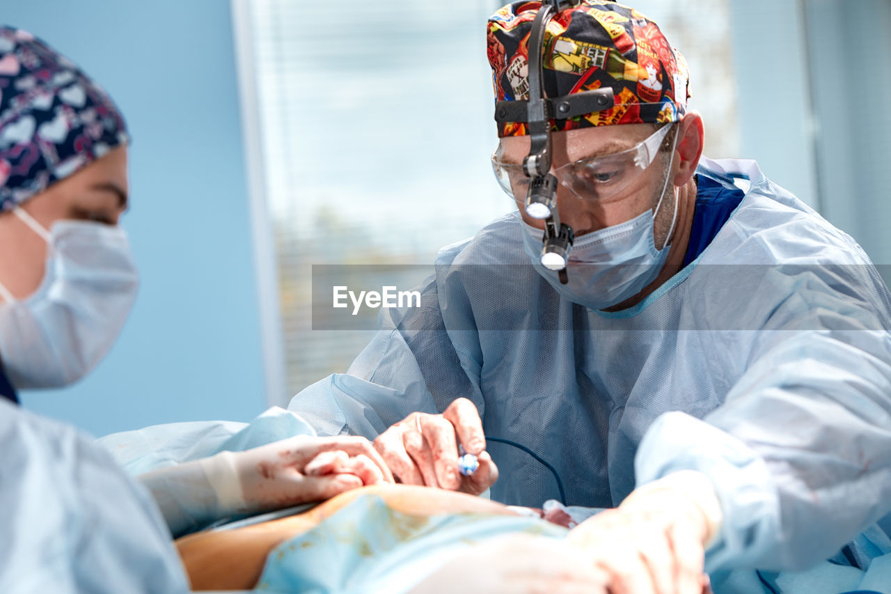rear view of doctor examining patient in clinic