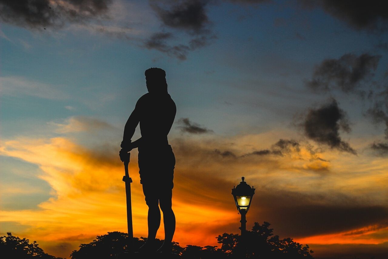 Low angle view of silhouette statue against sky during sunset