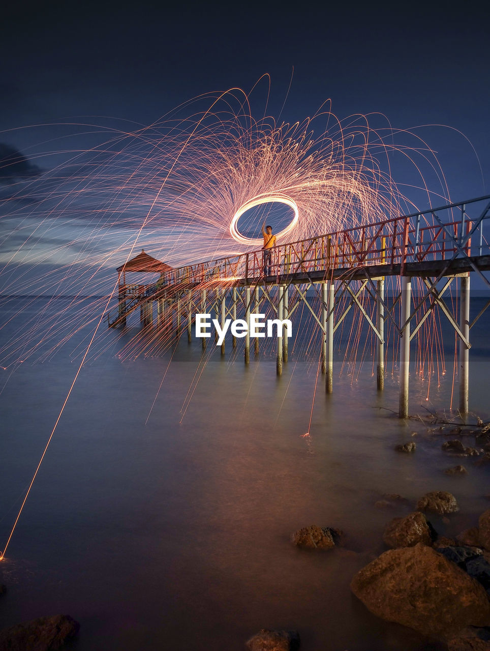 Bridge over river against sky at night