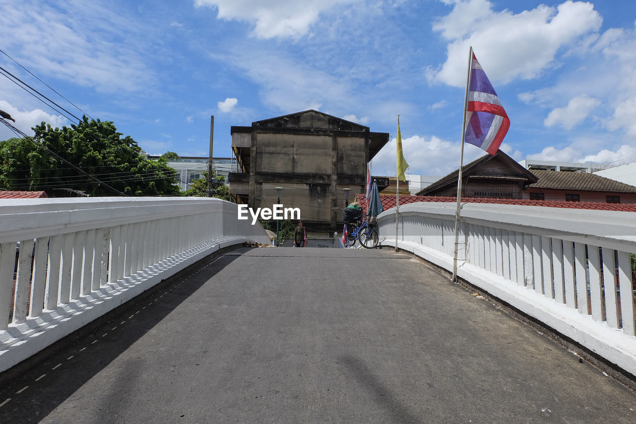 Woman on bridge against building in city