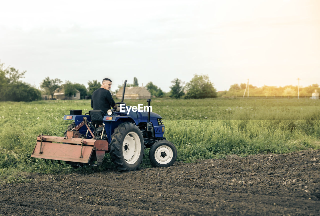 A farmer is driving a tractor across the field. mill grinding machine for soil. land cultivation. 