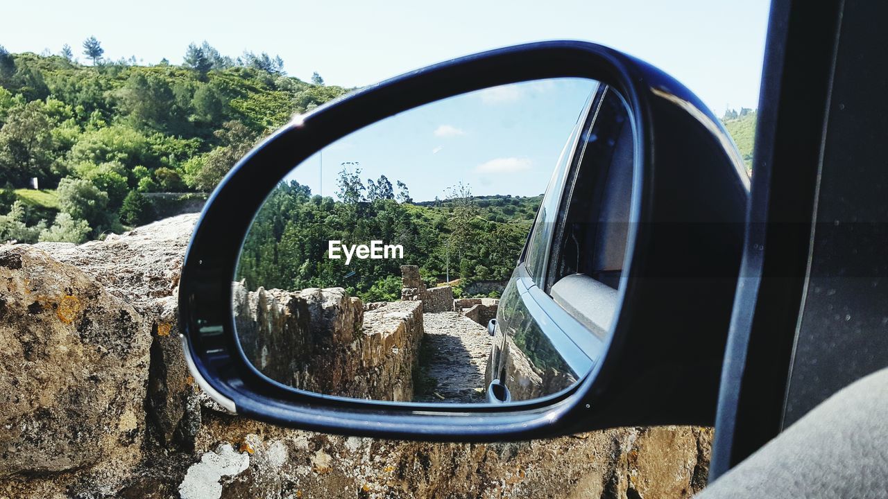 CLOSE-UP OF SIDE-VIEW MIRROR OF CAR