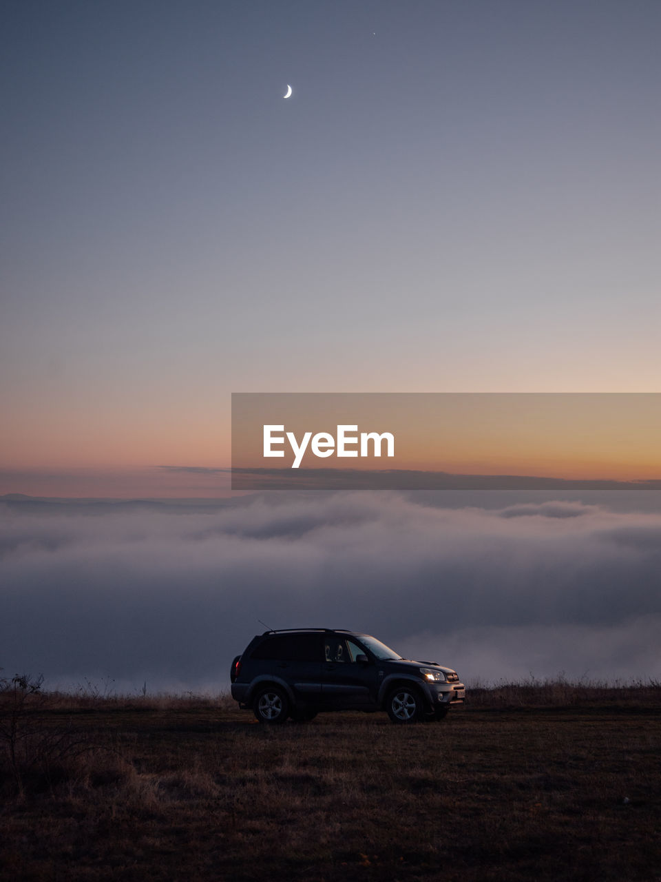 Car on land against sky during sunset