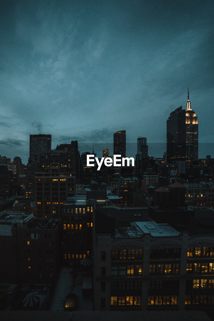 High angle view of illuminated buildings against sky at dusk