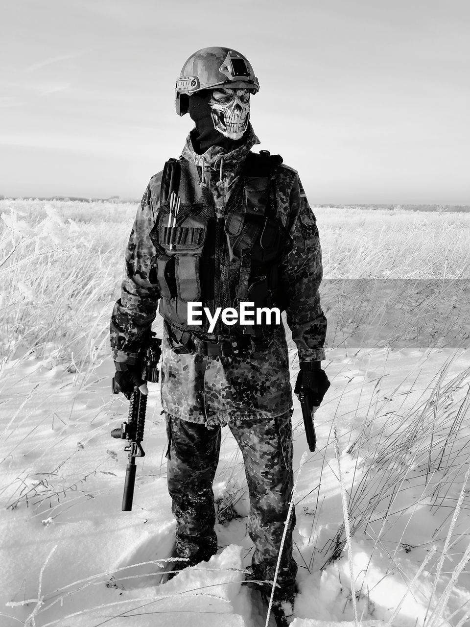 MAN STANDING ON SNOW COVERED LAND