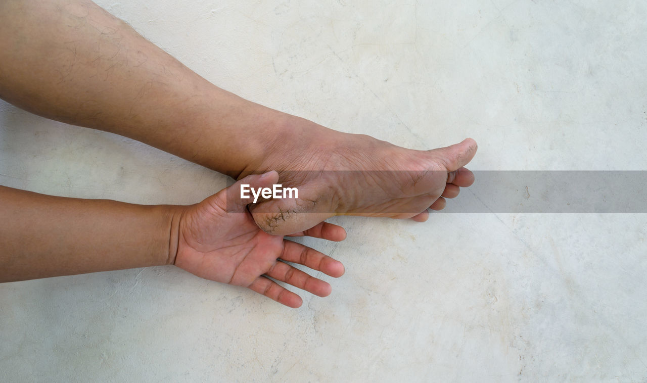 HIGH ANGLE VIEW OF PEOPLE HOLDING HANDS ON FLOOR