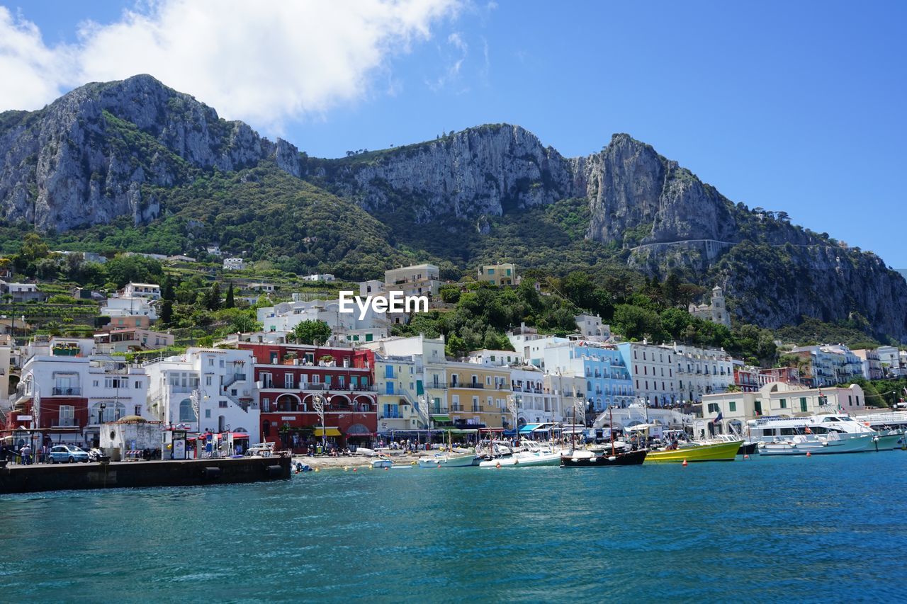 Sailboats in sea with city in background