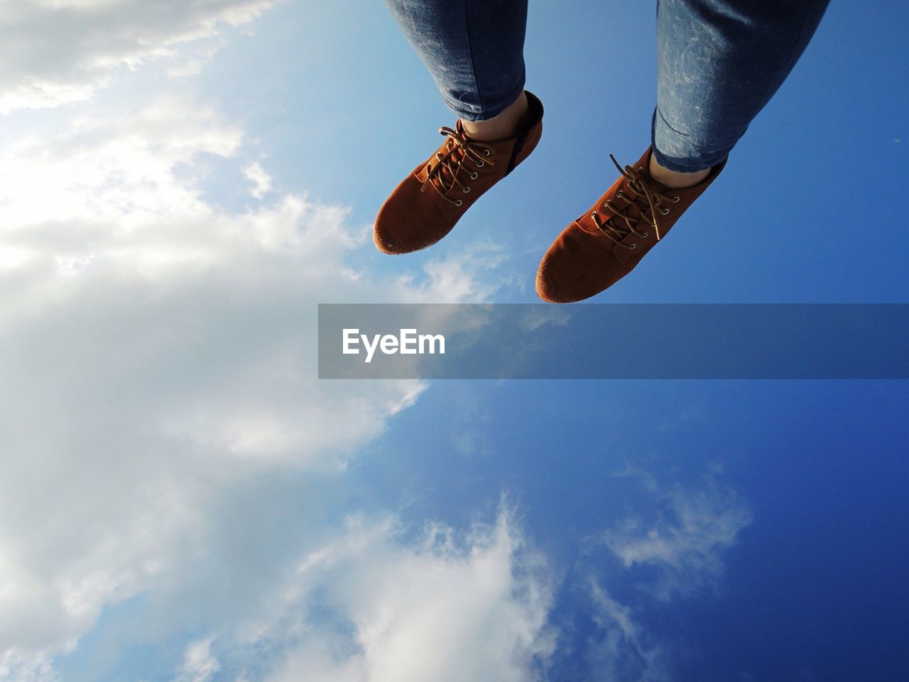 Low section of woman with feet up against sky