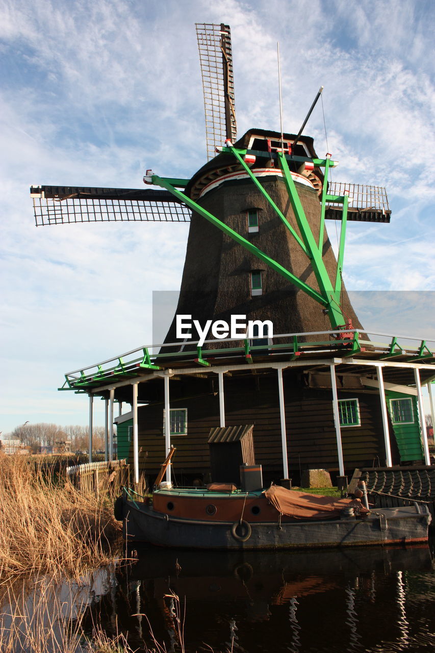 TRADITIONAL WINDMILL ON ROAD AGAINST SKY