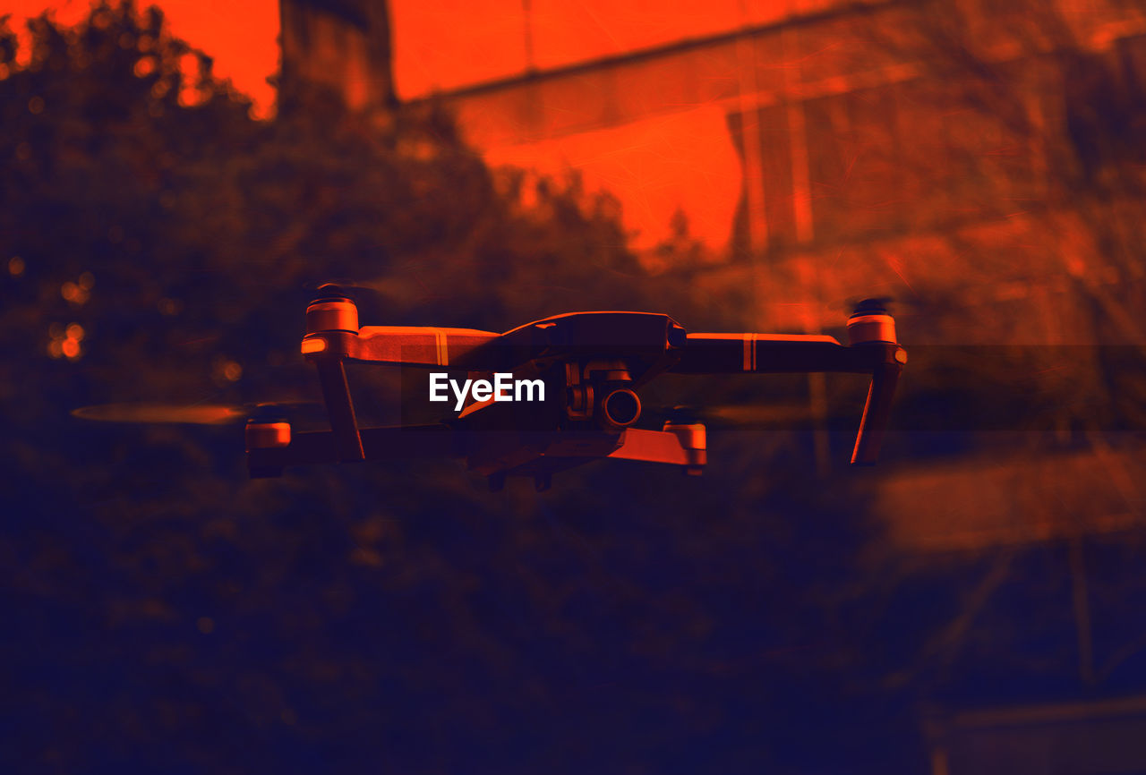 Close-up of drone in city during sunset