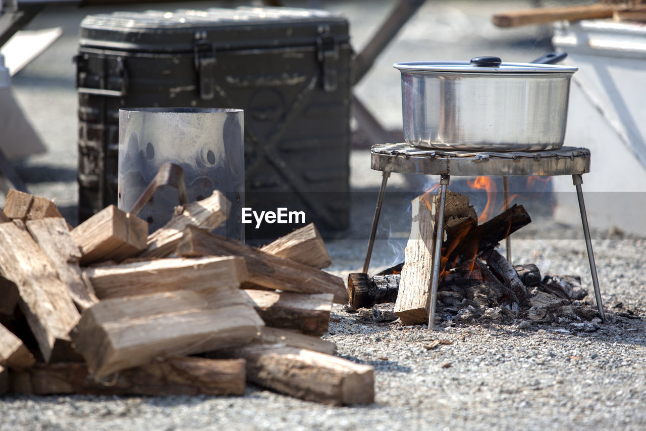 Burning firewood below stove at campsite