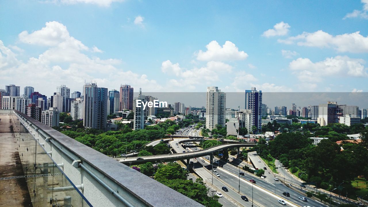 HIGH ANGLE VIEW OF CITYSCAPE AND HIGHWAY AGAINST SKY