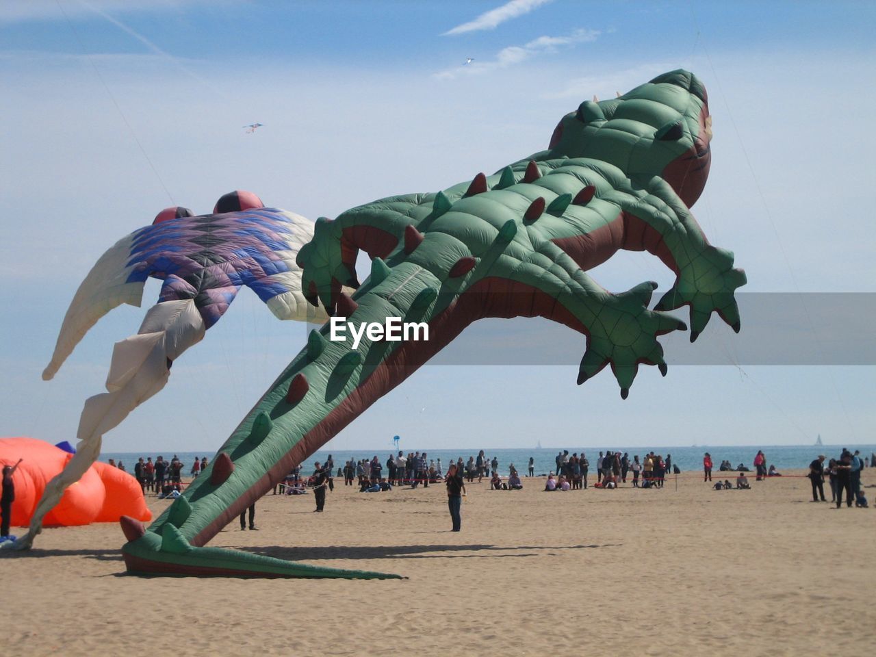 Large kites flying over beach against sky