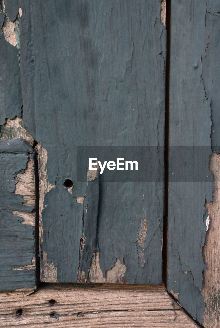 CLOSE-UP OF DAMAGED WOOD AGAINST WALL