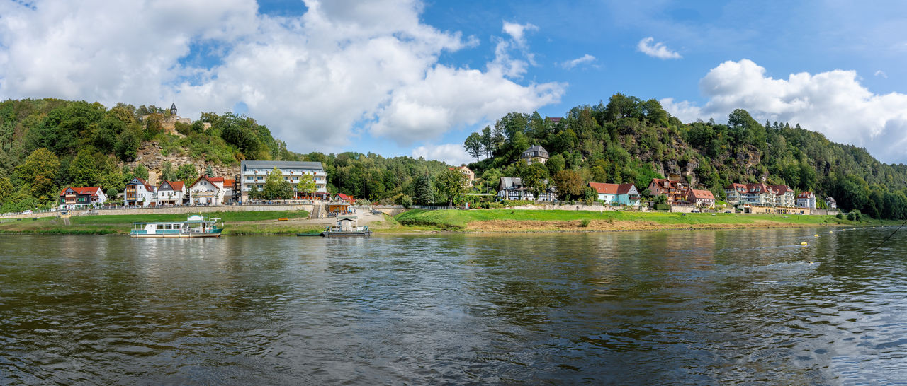 scenic view of river by trees against sky