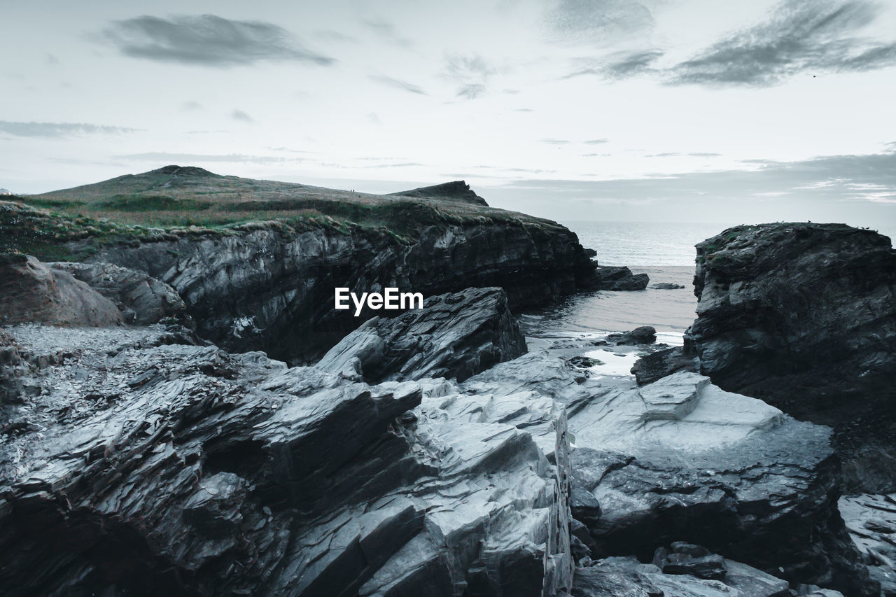 Rocks in sea against sky