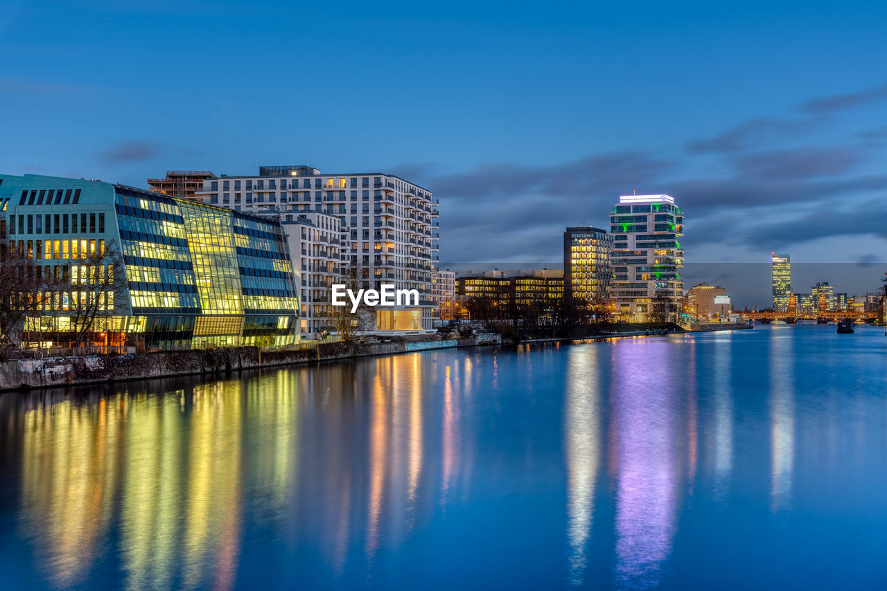 The river spree in berlin at night with modern buildings at the river banks