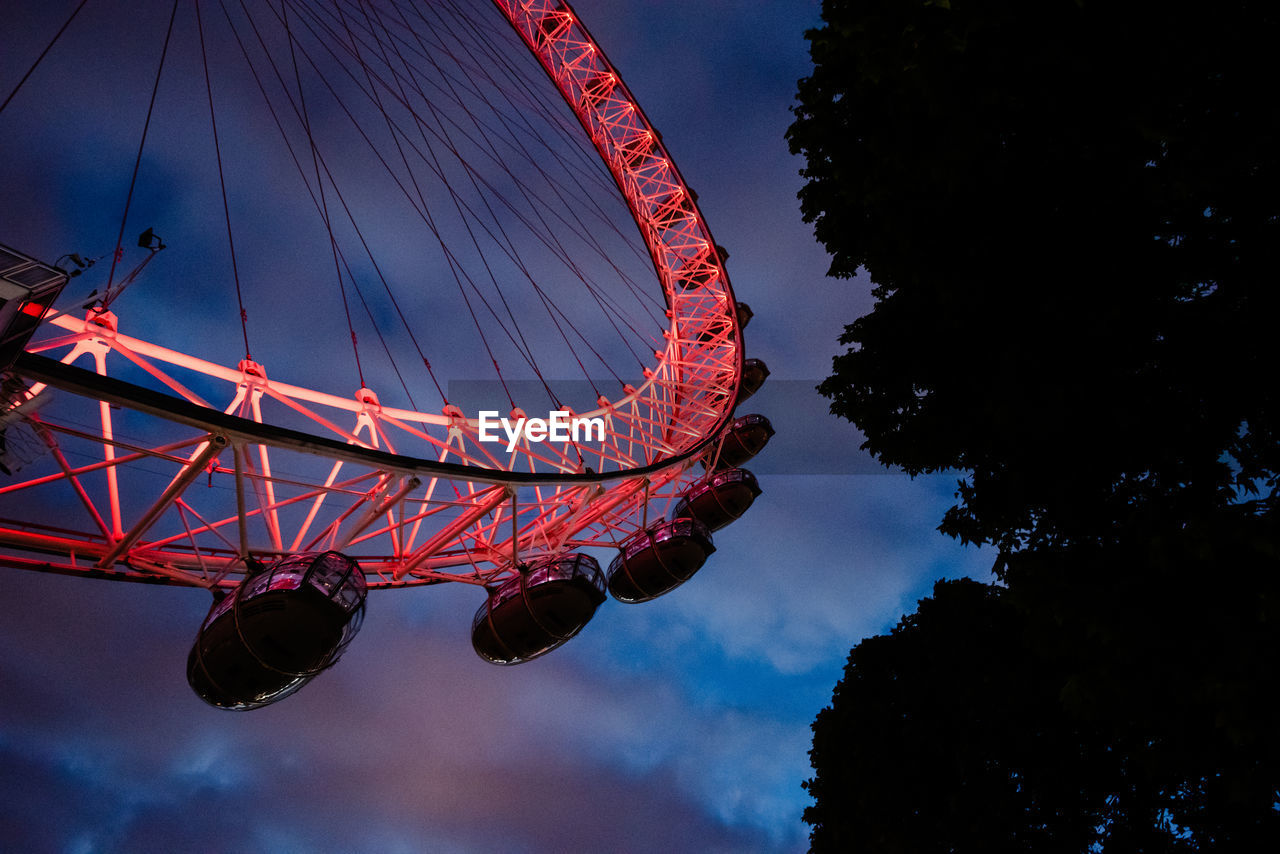 LOW ANGLE VIEW OF FERRIS WHEEL AGAINST BLUE SKY AT DUSK