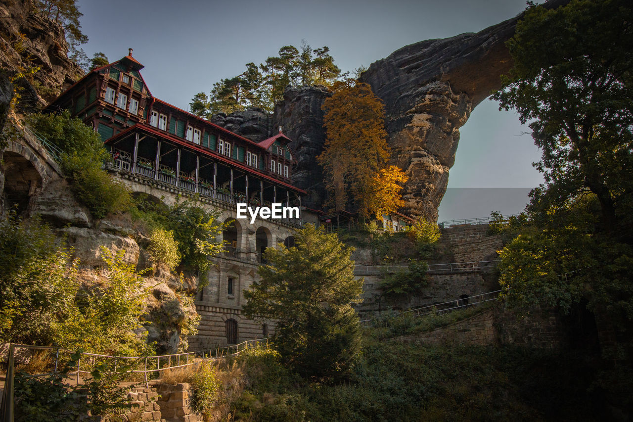 Low angle view of historical building against sky and natural arch