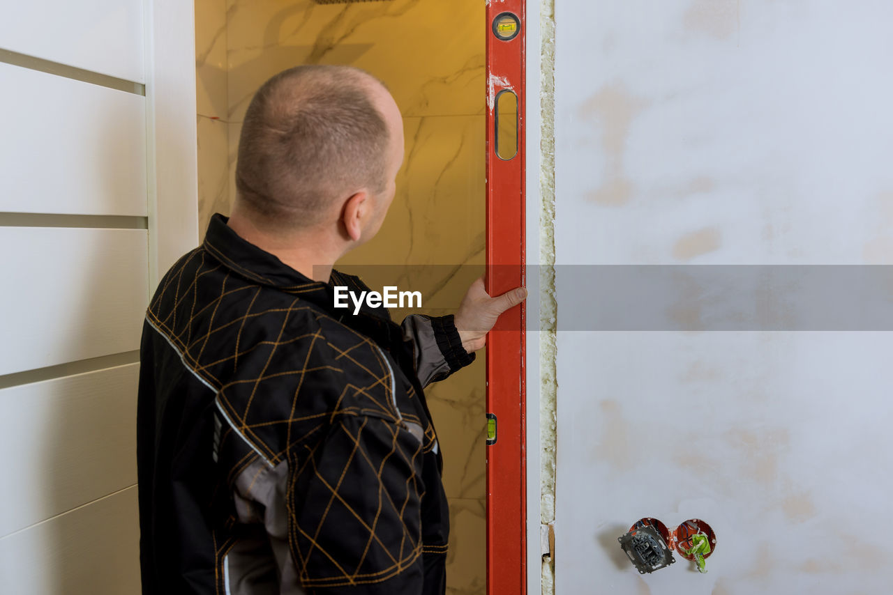 side view of man standing by wall