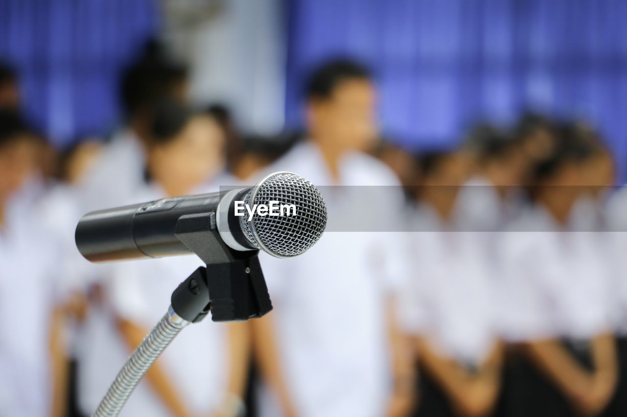 Close-up of microphone with people in background