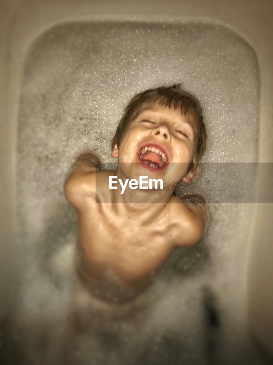 Close-up of happy boy in bathtub