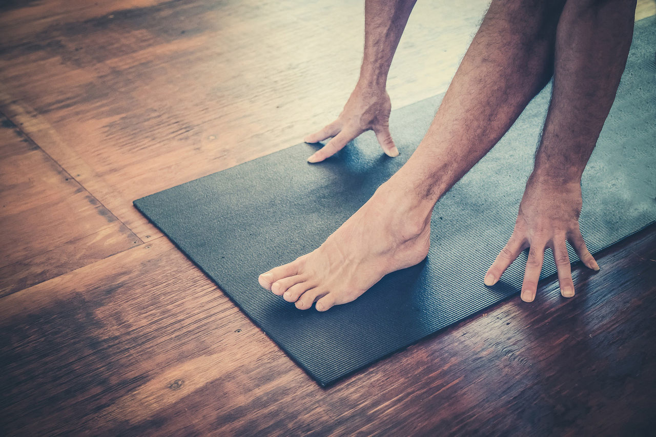 Low section of man exercising on hardwood floor