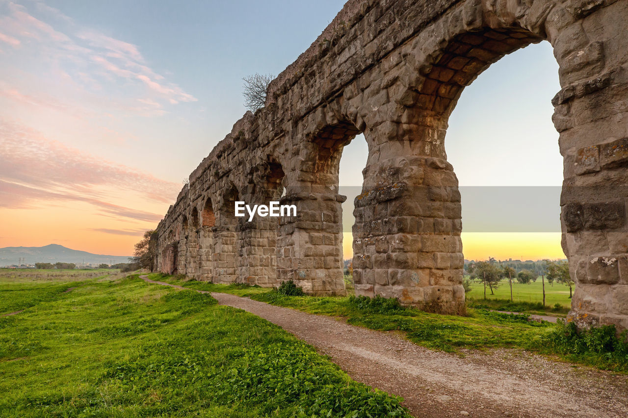 Aqueduct against sky at sunset