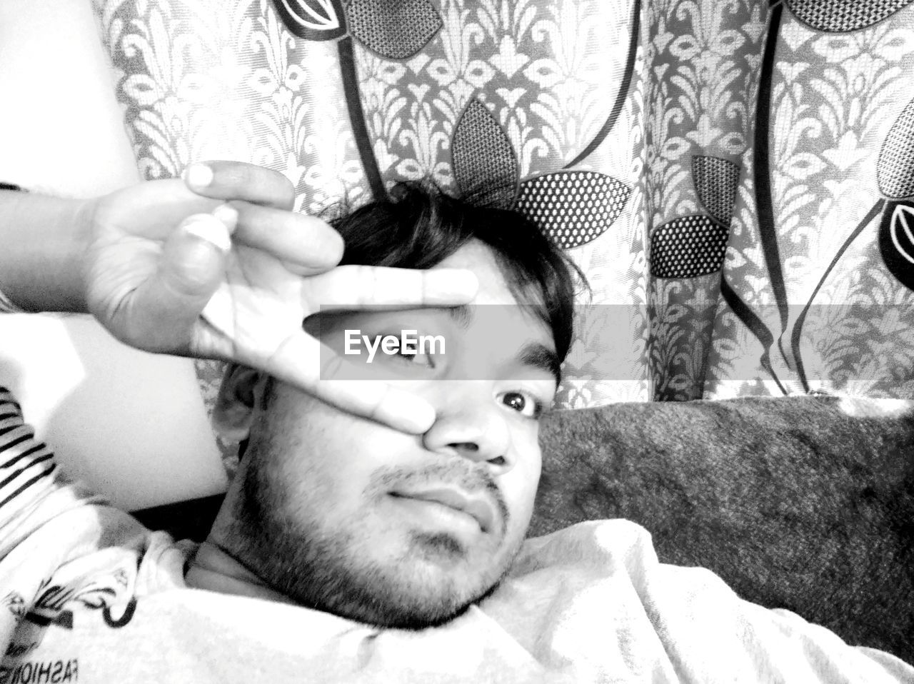 PORTRAIT OF MAN RELAXING ON BED
