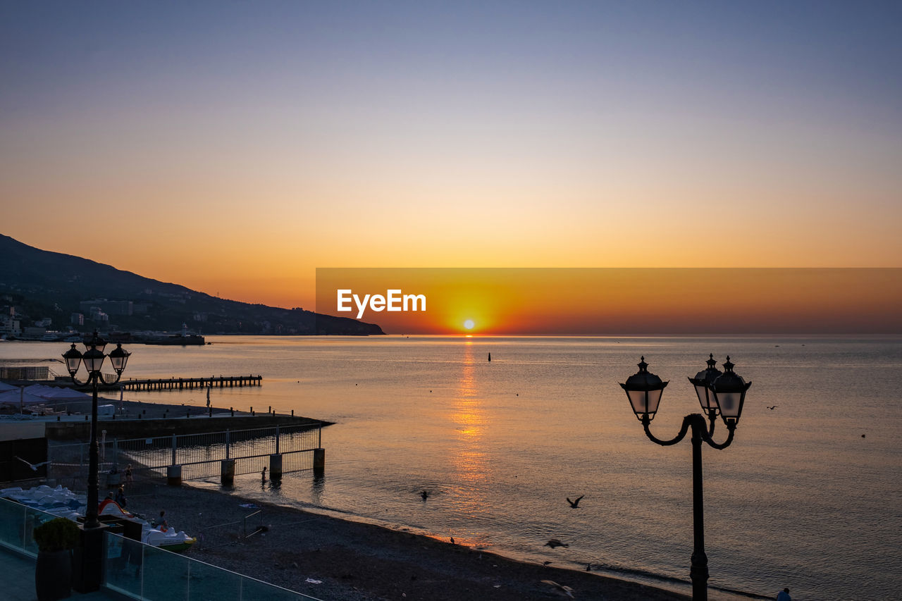 Scenic view of sea against clear sky during sunset