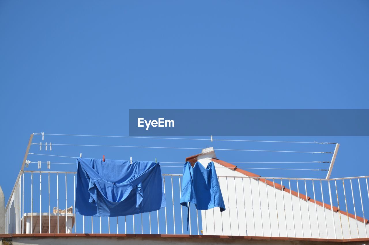 Low angle view of blue fabrics drying on clothesline