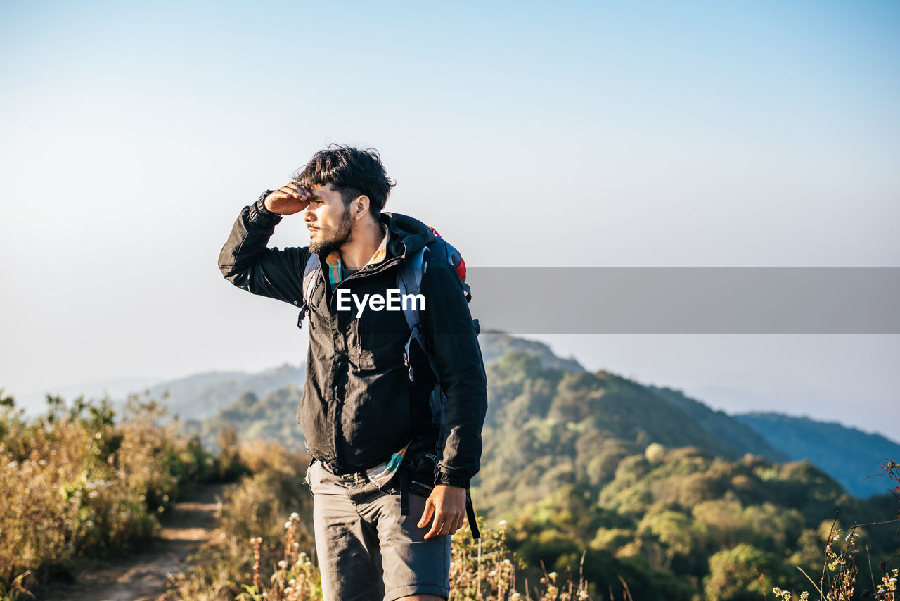 Man standing on mountain against clear sky