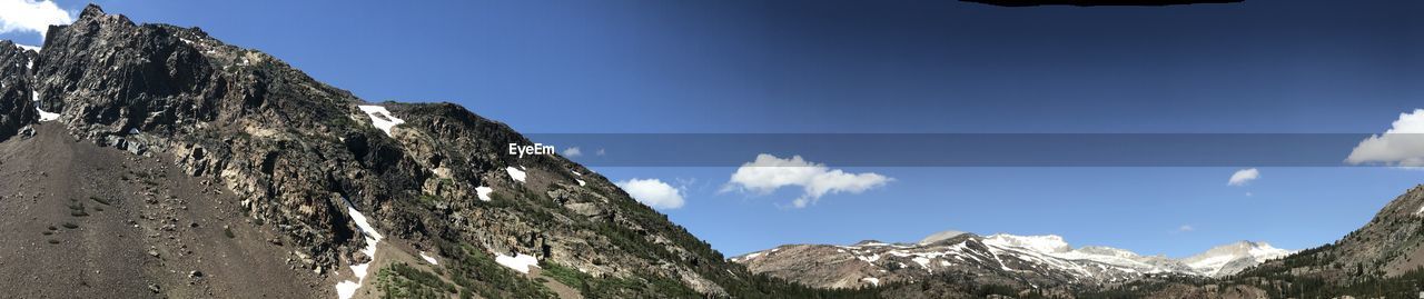 Low angle view of snowcapped mountains against blue sky