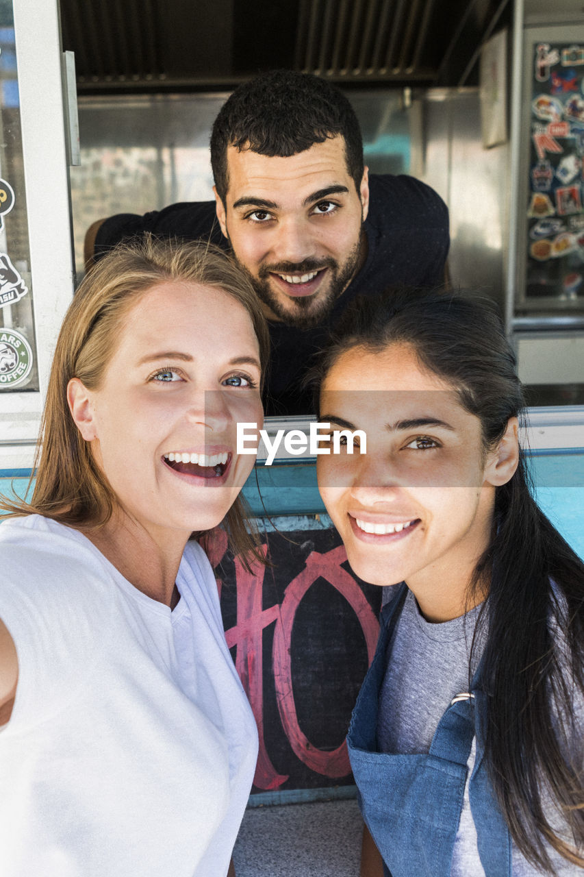 Portrait of confident young multi-ethnic colleagues at concession stand