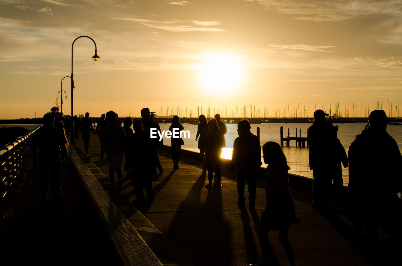 sunset, sky, silhouette, evening, group of people, crowd, nature, water, large group of people, dusk, sea, cloud, sunlight, transportation, men, architecture, back lit, adult, sun, women, lifestyles, travel, outdoors, beach, travel destinations, city, leisure activity, horizon, vacation, trip