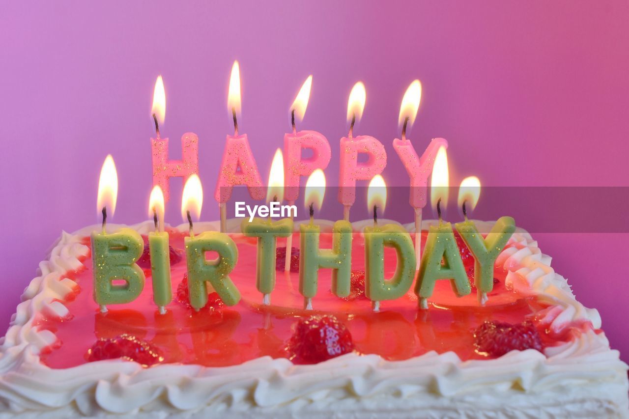 Close-up of birthday cake against pink background