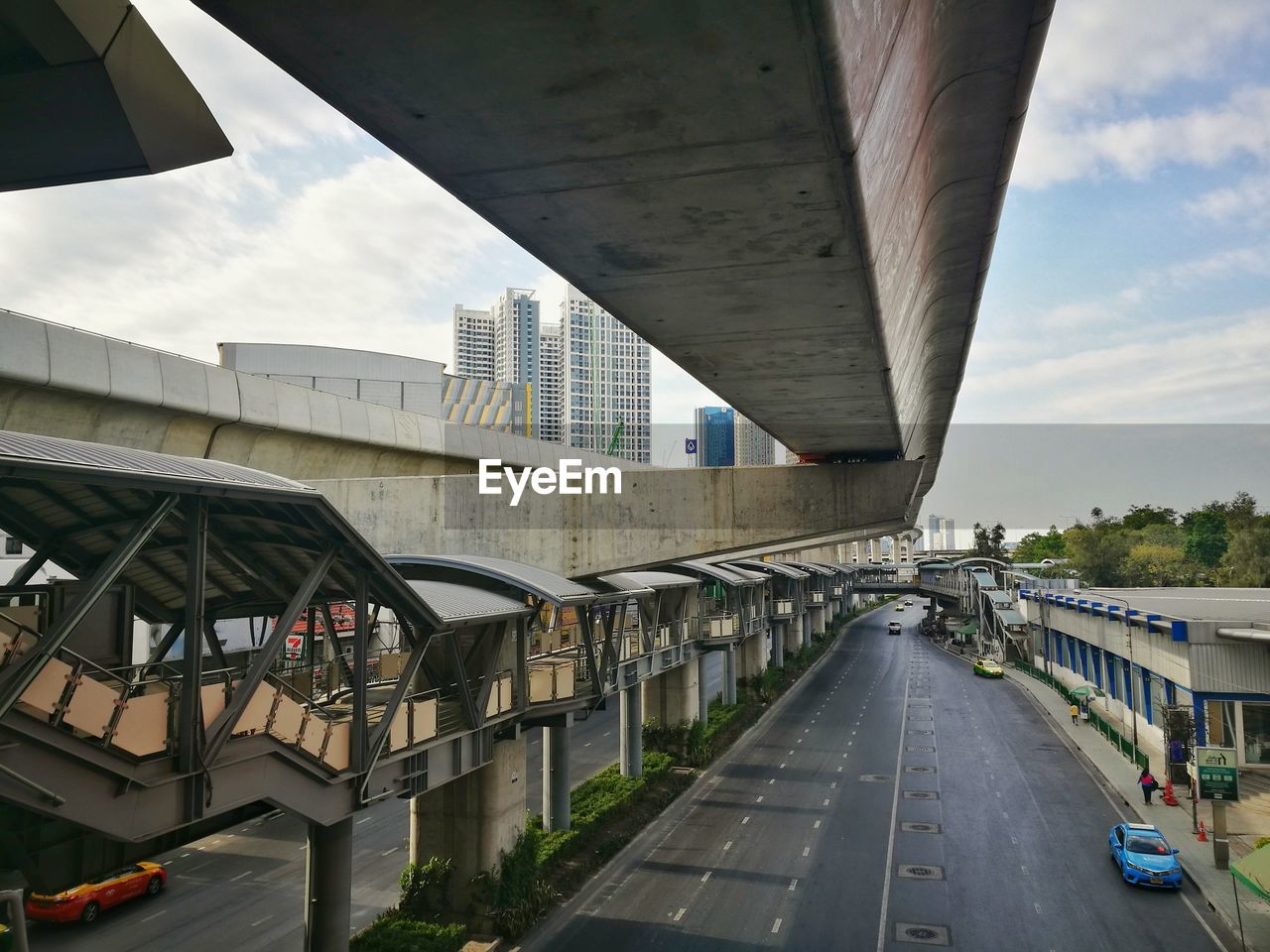 BRIDGE OVER ROAD BY BUILDINGS AGAINST SKY