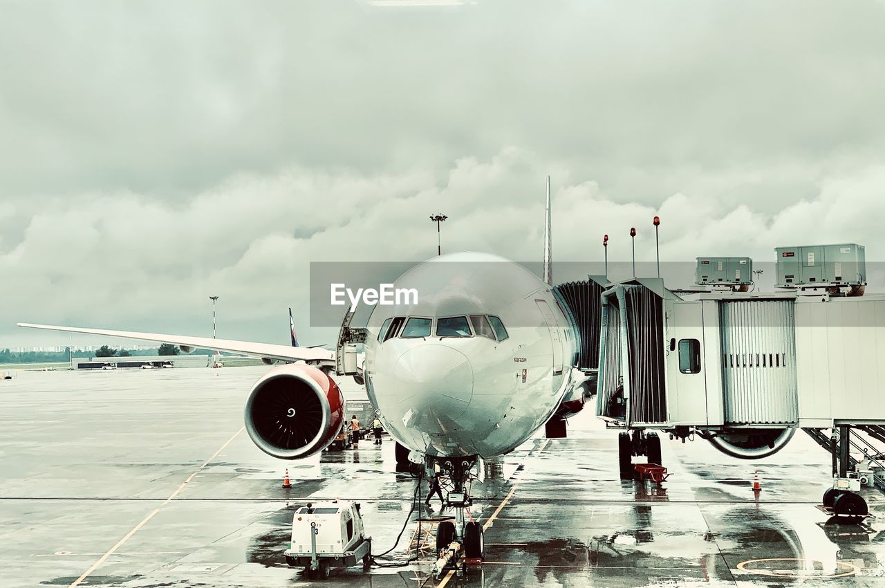 Airplane on airport runway against sky