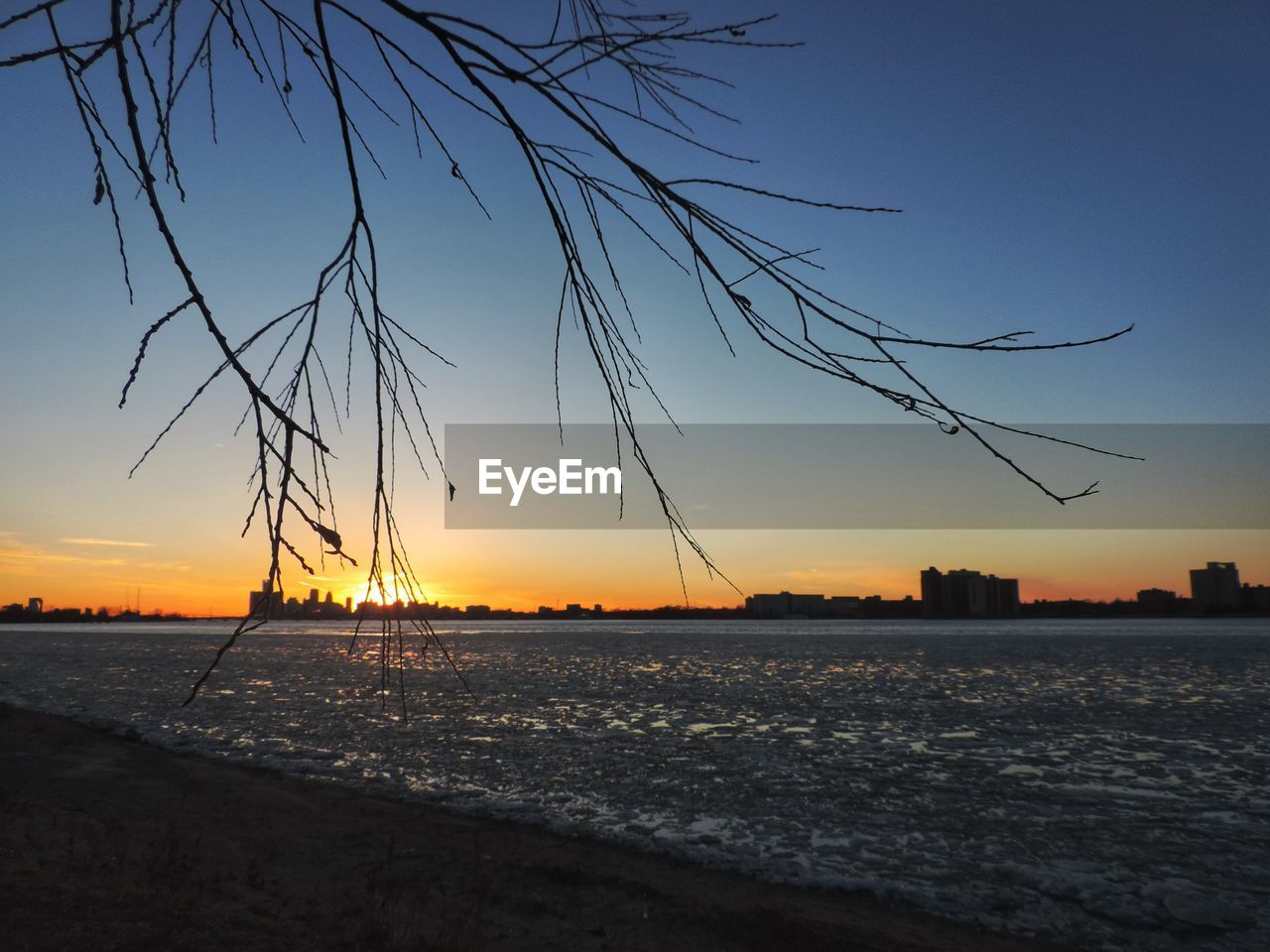 Scenic view of frozen river against sky during sunset