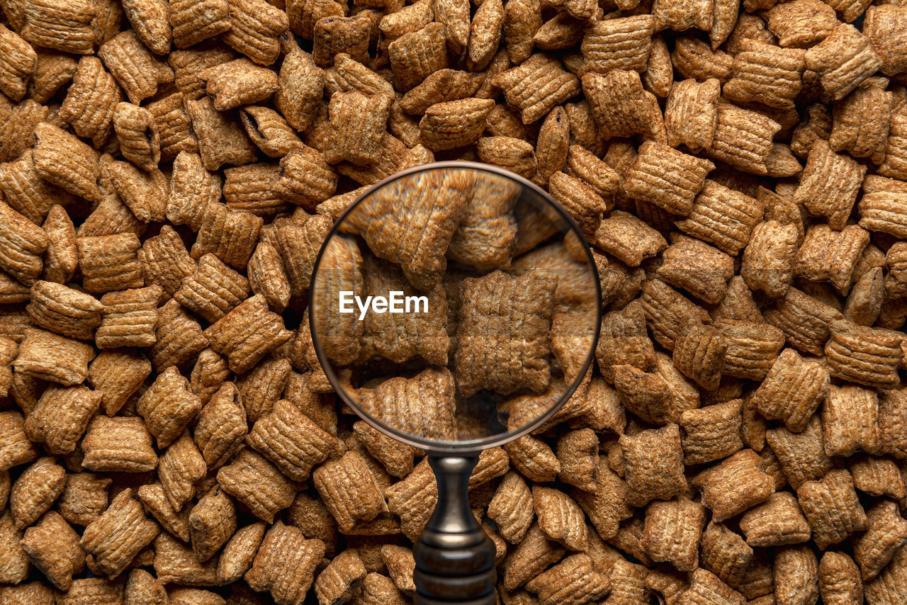 Breakfast caramel cereals square-shaped with chocolate filling, view through a magnifying glass. 