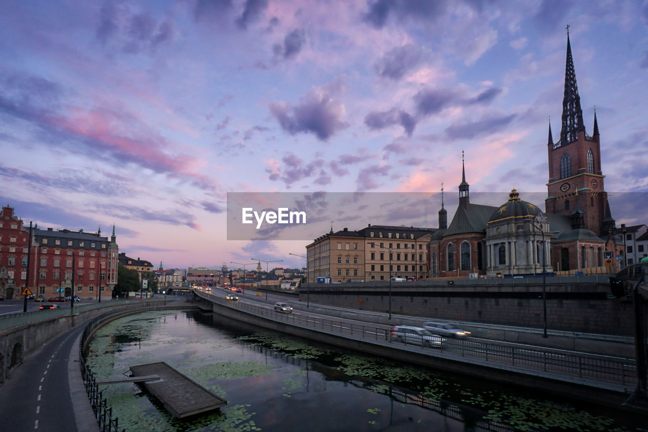 View of buildings against cloudy sky in sunset 