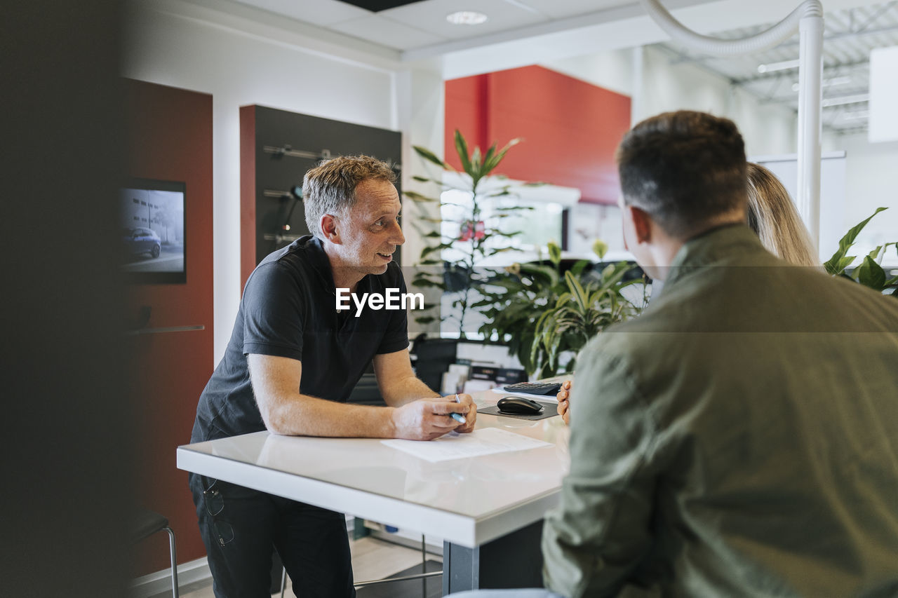 Salesman talking with customers